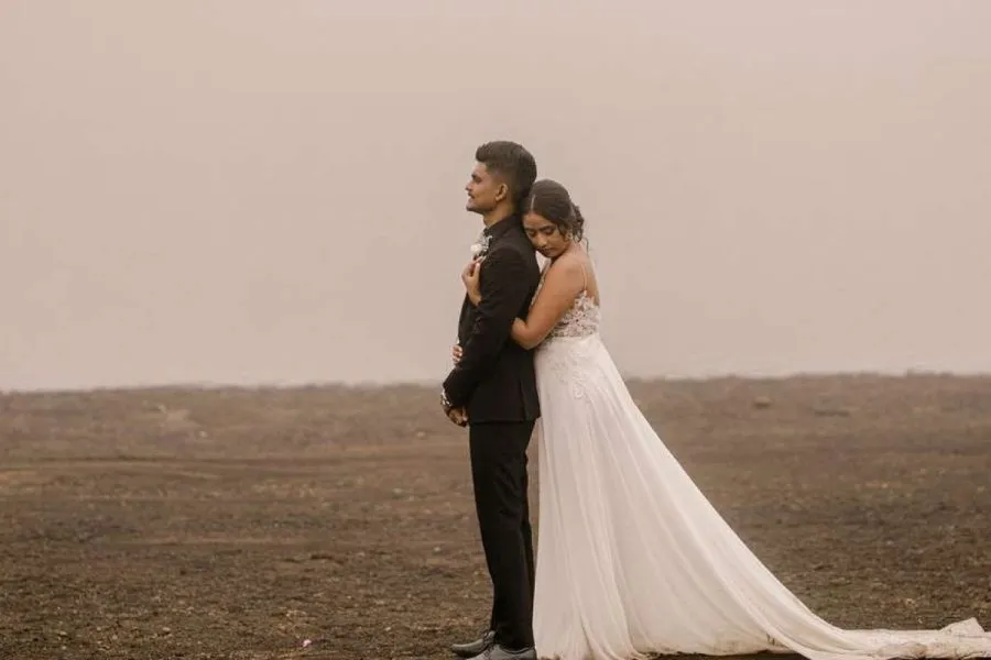 Engaged couple embracing in an open field