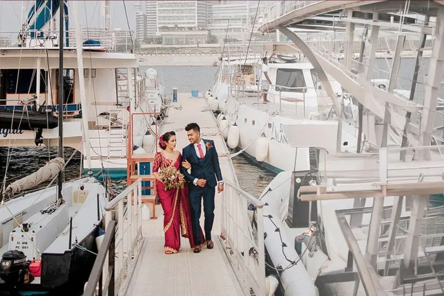 Homecoming couple walking along a marina jetty