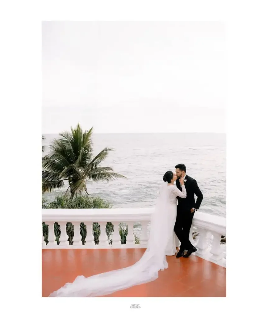 Couple sharing a kiss on a seaside balcony