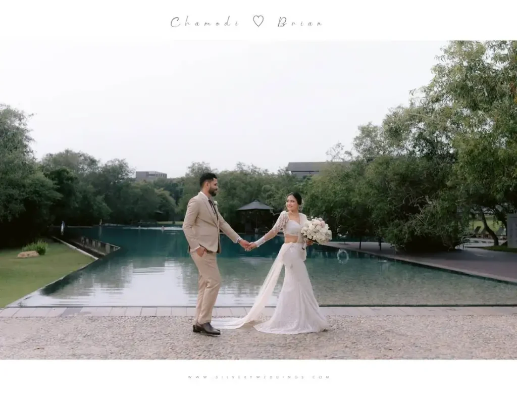 Chamodi and Brian walking hand in hand by a pool