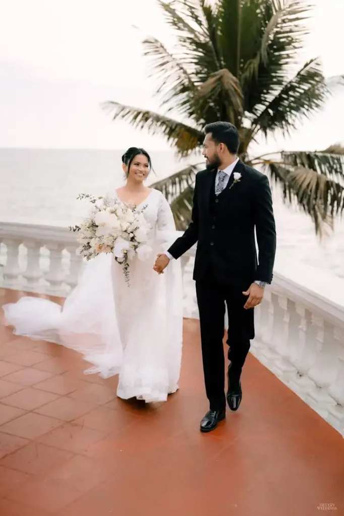 Couple walking on a balcony beside a palm tree